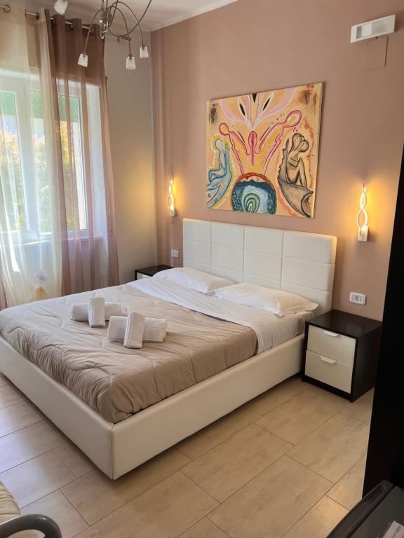 プラーイア・ア・マーレにあるB&B Villa degli Angeliの壁に絵画が描かれたベッドルームの大型ベッド1台