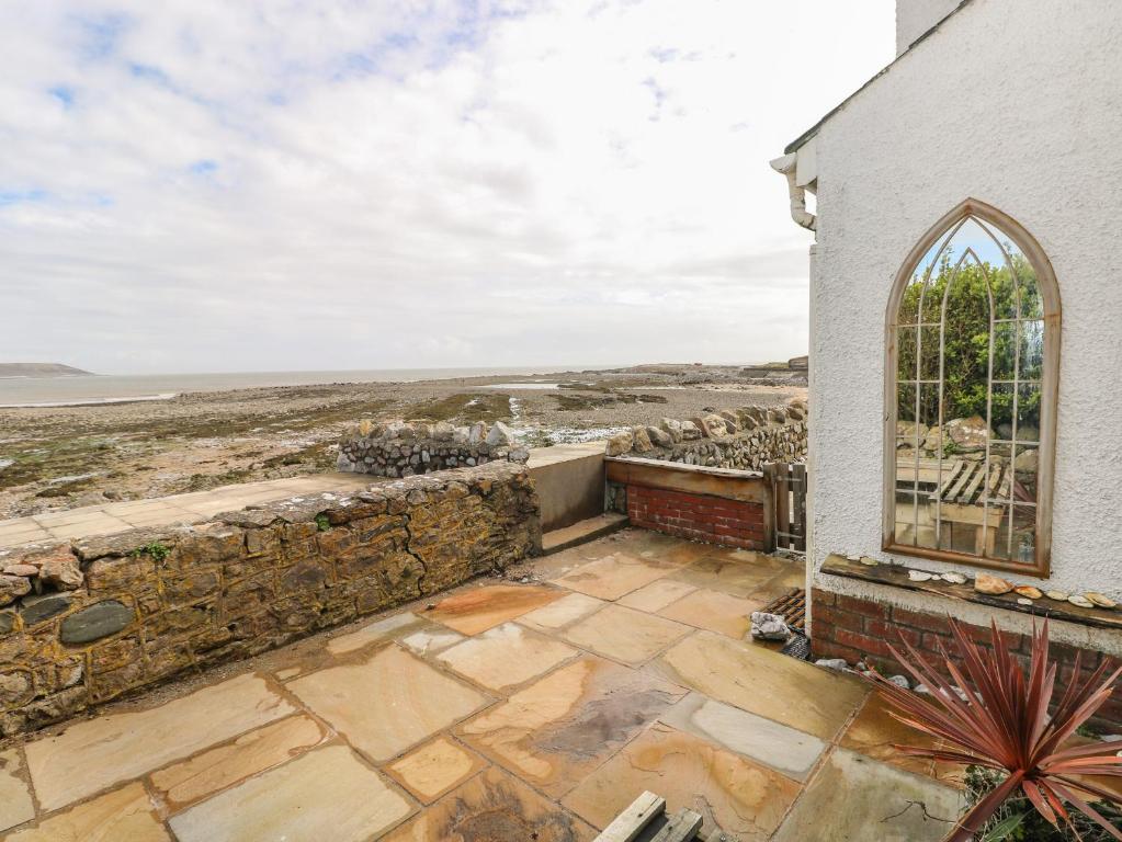 an image of a church with a view of the ocean at 1 Salt Cottage in Swansea