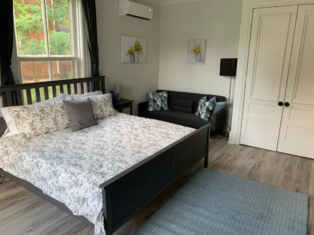 a bedroom with a large bed and a couch at County Cove - Picton Suite in Wellington