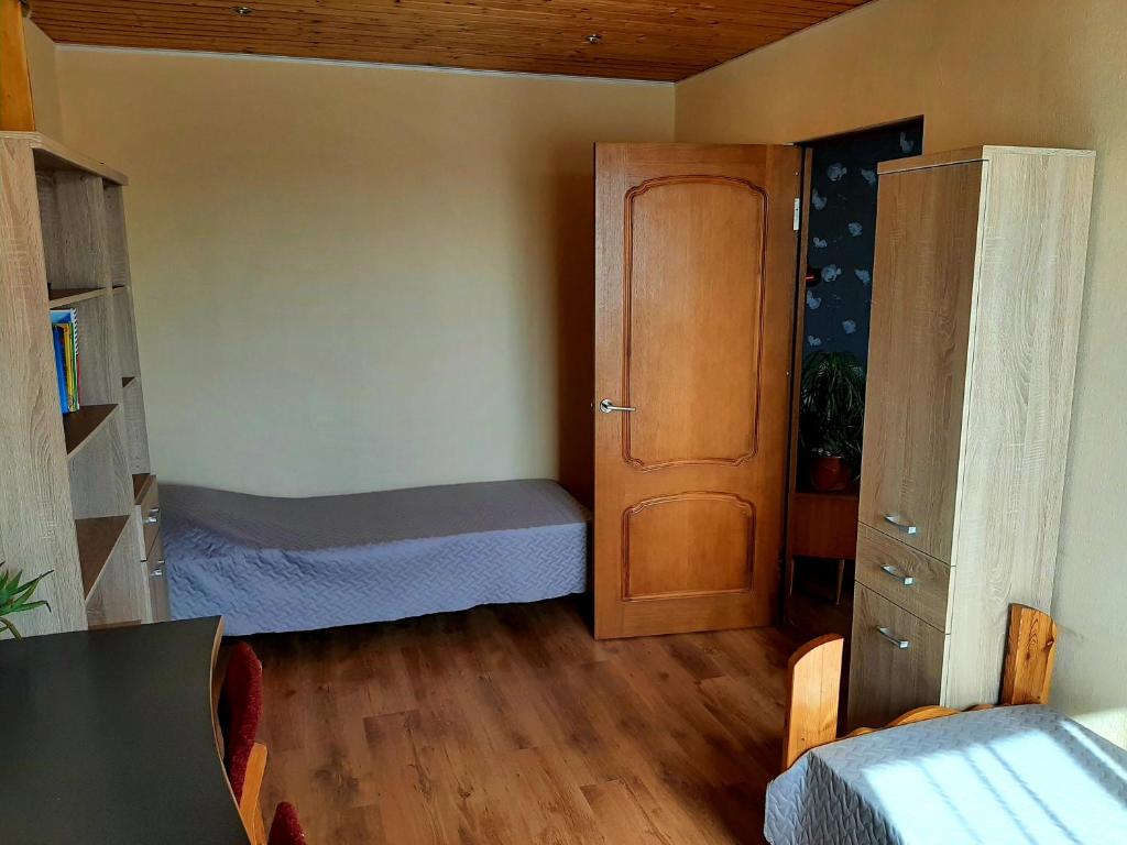a small bedroom with a bed and a closet at Dzintaru 97 in Pāvilosta