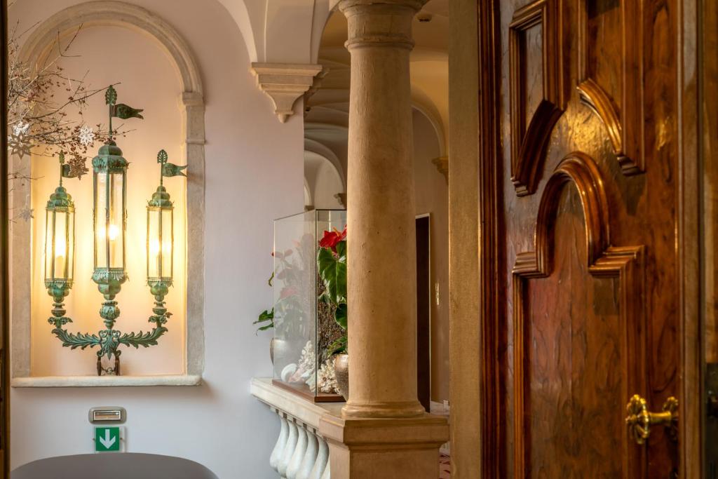 a hallway with a pillar and a vase on a shelf at Excess Venice Boutique Hotel & Private Spa - Adults Only in Venice