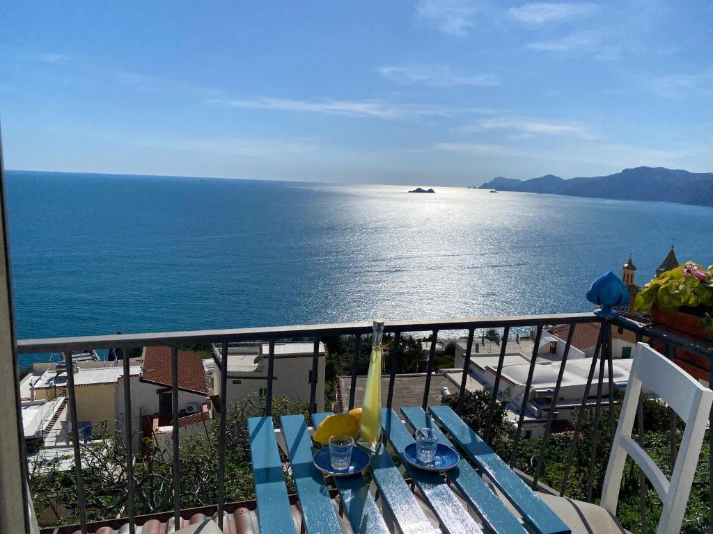 a table on a balcony with a view of the ocean at IL PROFUMO DEI FIORI SUITE in Praiano