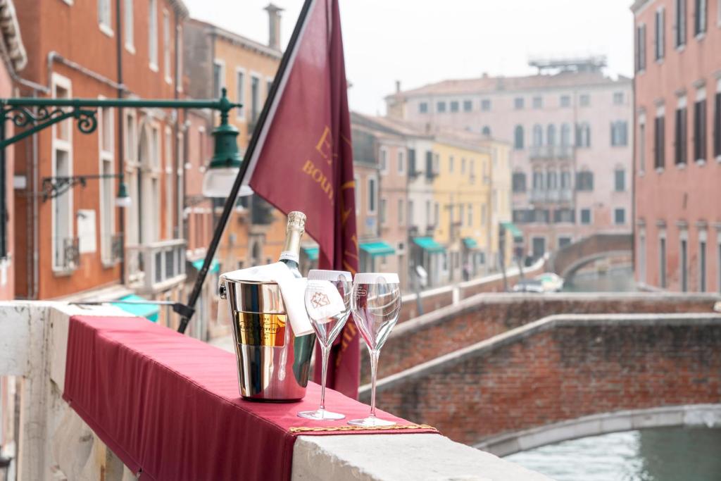 a table with two wine glasses and a flag at Excess Venice Boutique Hotel & Private Spa - Adults Only in Venice