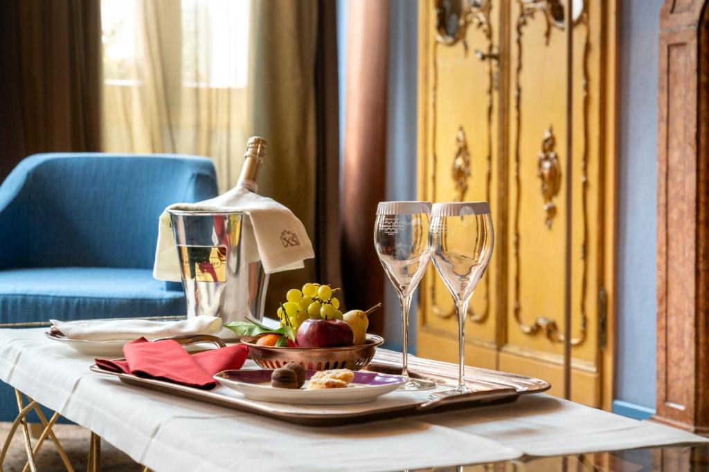 a table with a plate of food and two wine glasses at Excess Venice Boutique Hotel & Private Spa - Adults Only in Venice