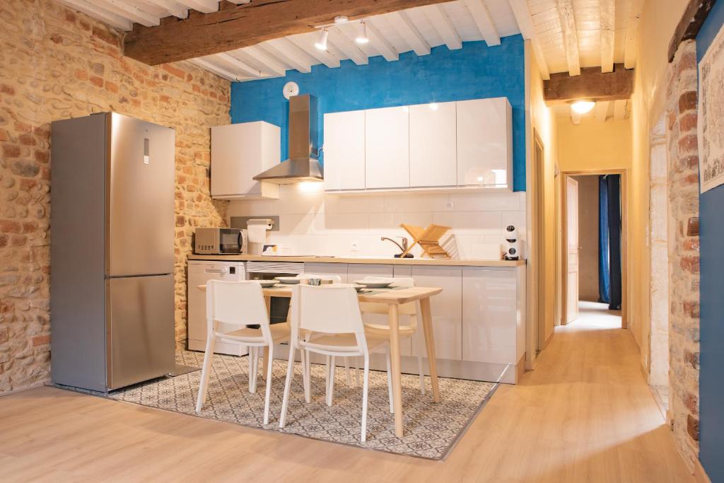 eine Küche mit weißen Schränken sowie einem Tisch und Stühlen in der Unterkunft Renaissance in Bourg-en-Bresse