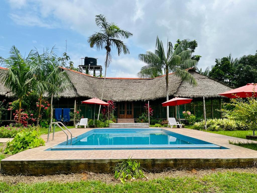 a villa with a swimming pool in front of a house at Estancia Bello Horizonte in Puerto Maldonado
