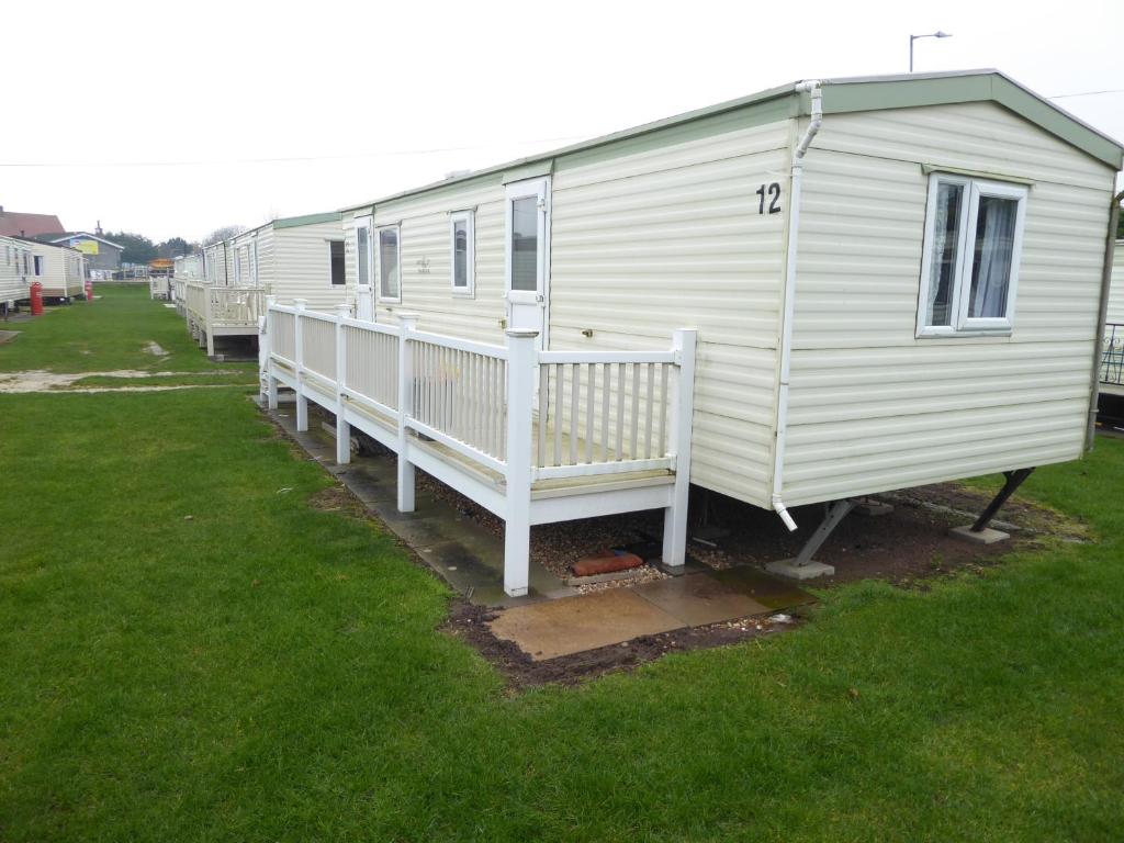 a row of mobile homes parked in a yard at Beachside, Family-friendly, WiFi, 6 berth Caravan 12 in Ingoldmells