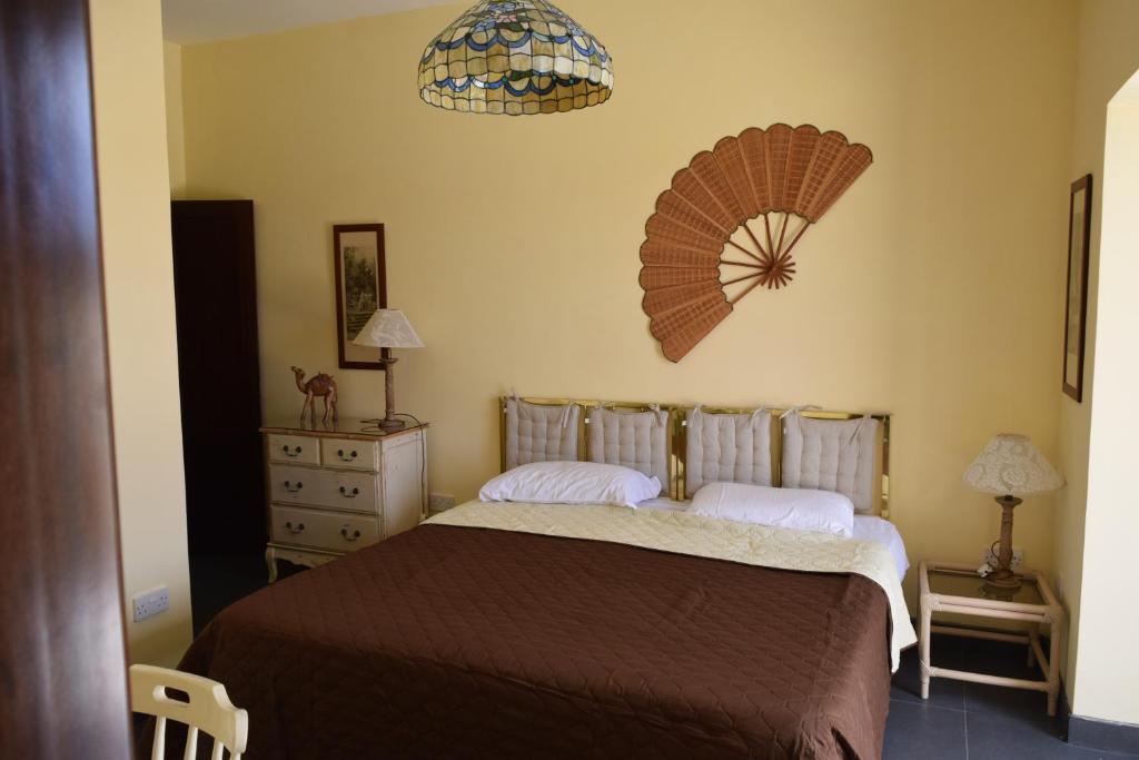a bedroom with a bed and a fan on the wall at Gmiel in-Natura B&B in Għajn il-Kbira