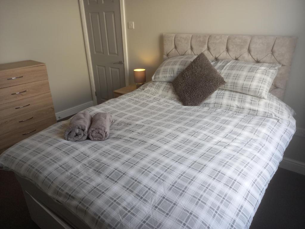 Una cama con dos animales de peluche encima. en Springfield Gardens - Ilkeston - Close to M1-A52 Long Eaton - Nottingham - Derbyshire - 500Mbs WiFi! en Ilkeston