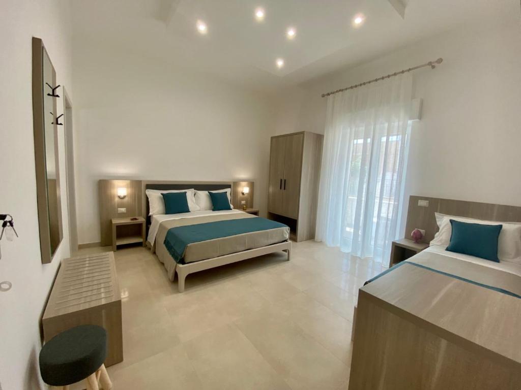 a bedroom with two beds and a large window at B&B MarAlè in Porto Cesareo