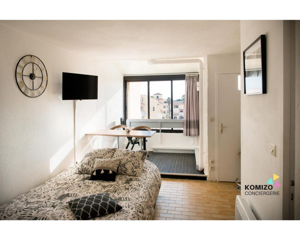 une chambre avec un lit, une table et une fenêtre dans l'établissement La Sentinelle, à Leucate