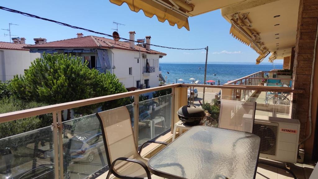 Un balcón con una silla y vistas al océano. en Eldana First line with Shared Pool, en Gerakini