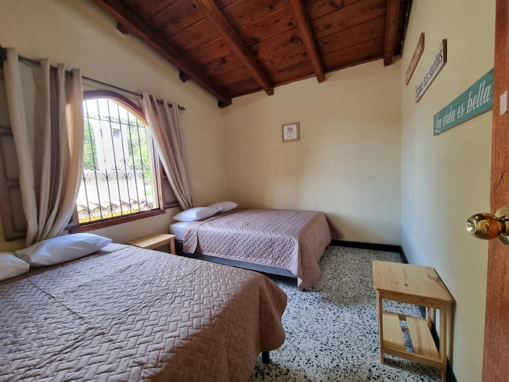 a bedroom with two beds and a window at Central Hostel in Antigua Guatemala