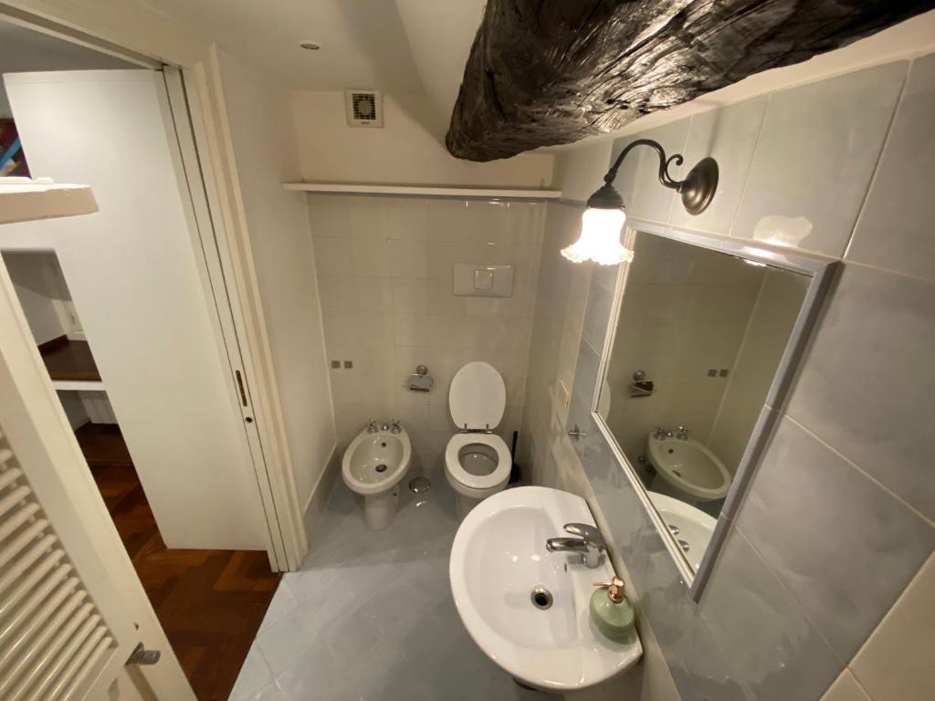 łazienka z umywalką, toaletą i lustrem w obiekcie Casa Tre Re w mieście Neapol