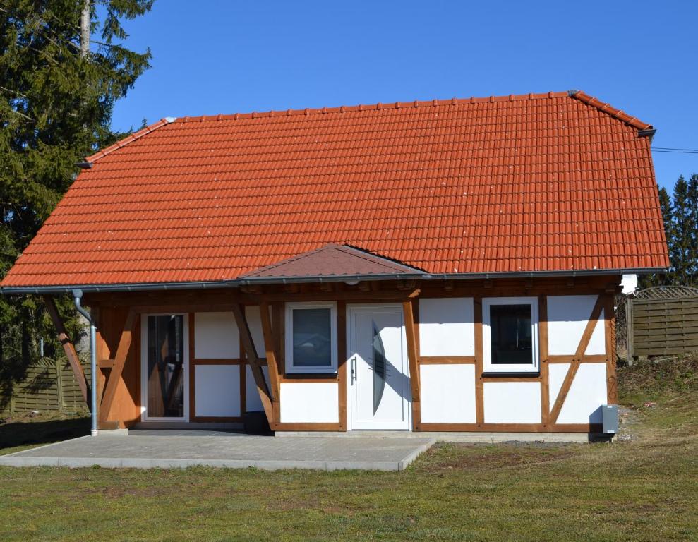 una pequeña casa con techo naranja en HM - Ferienhaus 1 Deluxe Krombachtalsperre Westerwald exklusive verbrauchte NK, en Driedorf