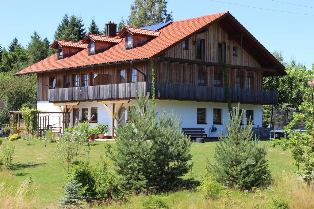 een groot houten huis met een rood dak bij Gästehaus zum Prinzenfelsen in Nagel