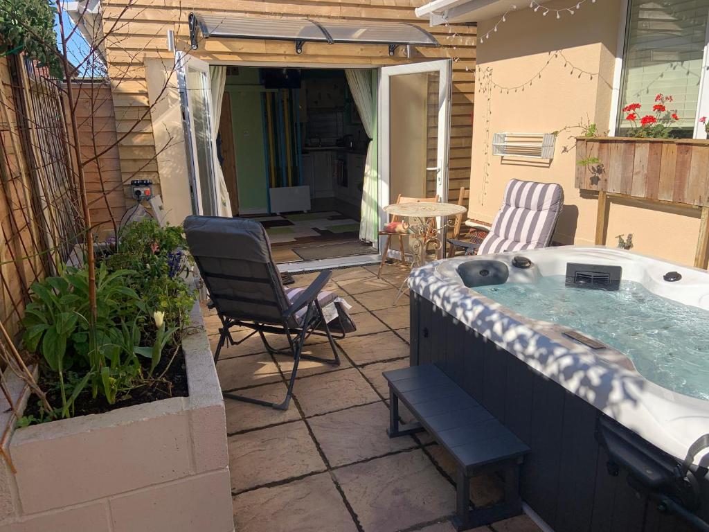 a hot tub on a patio with a table and chairs at The Barn in South Hayling