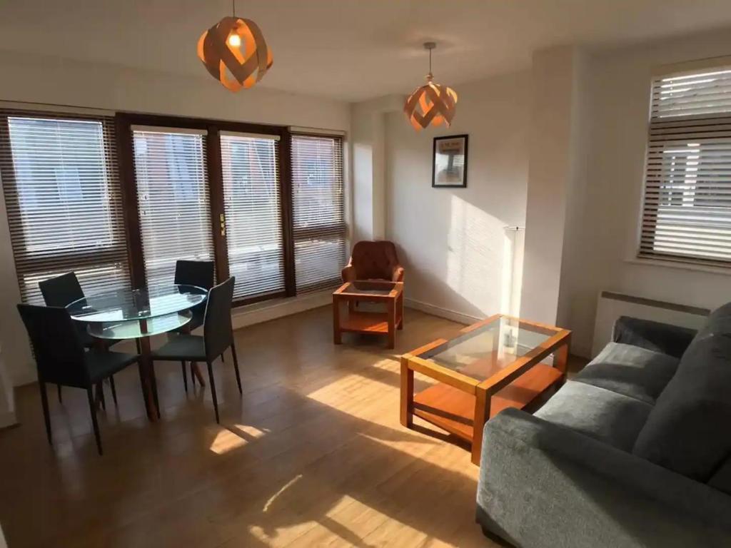 a living room with a couch and a table and chairs at Central Spacious Apartment w/ Balcony & City View in Dublin