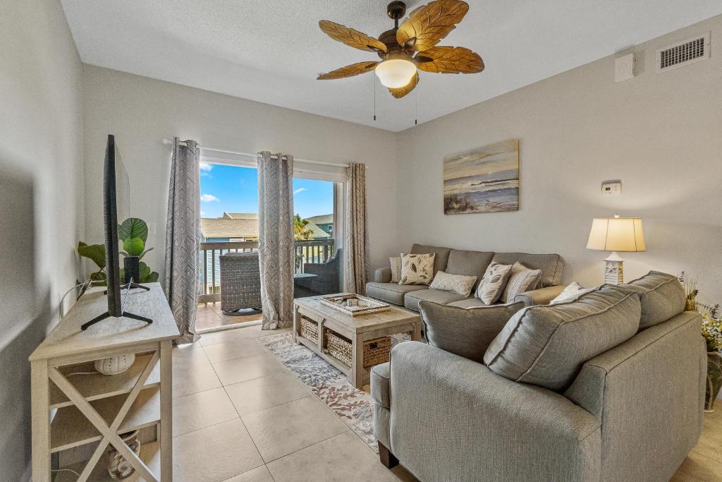 a living room with a couch and a ceiling fan at Villas on the Gulf J6 in Pensacola Beach