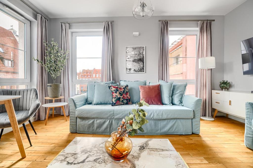 a living room with a blue couch and a table at Apartament 222 stare miasto Apartamenty No 1 in Szczecin