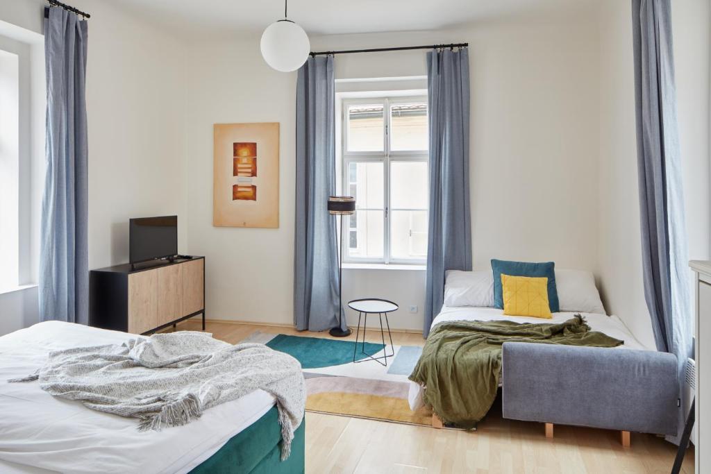 a bedroom with a bed and a couch and a window at Renovated Flat in Old Town Square by Prague Days in Prague