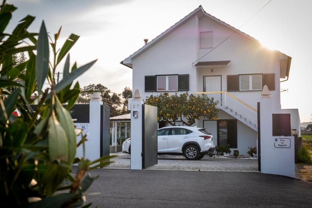 uma casa branca com um carro estacionado na garagem em Casa O Limoeiro em Ponte de Lima