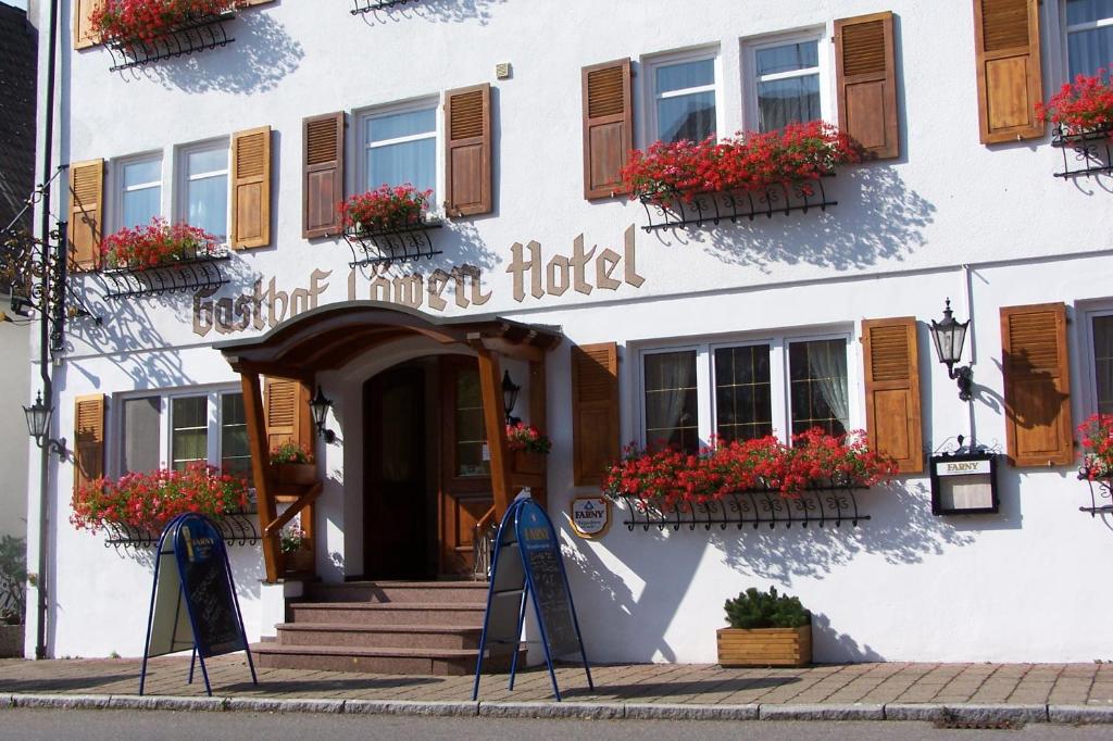 ein Hotel mit Blumen vor einem Gebäude in der Unterkunft Gasthof Hotel Löwen in Bad Buchau