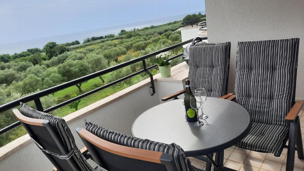 a table and chairs on a balcony with a view at Apartma Coccolo in Zambratija