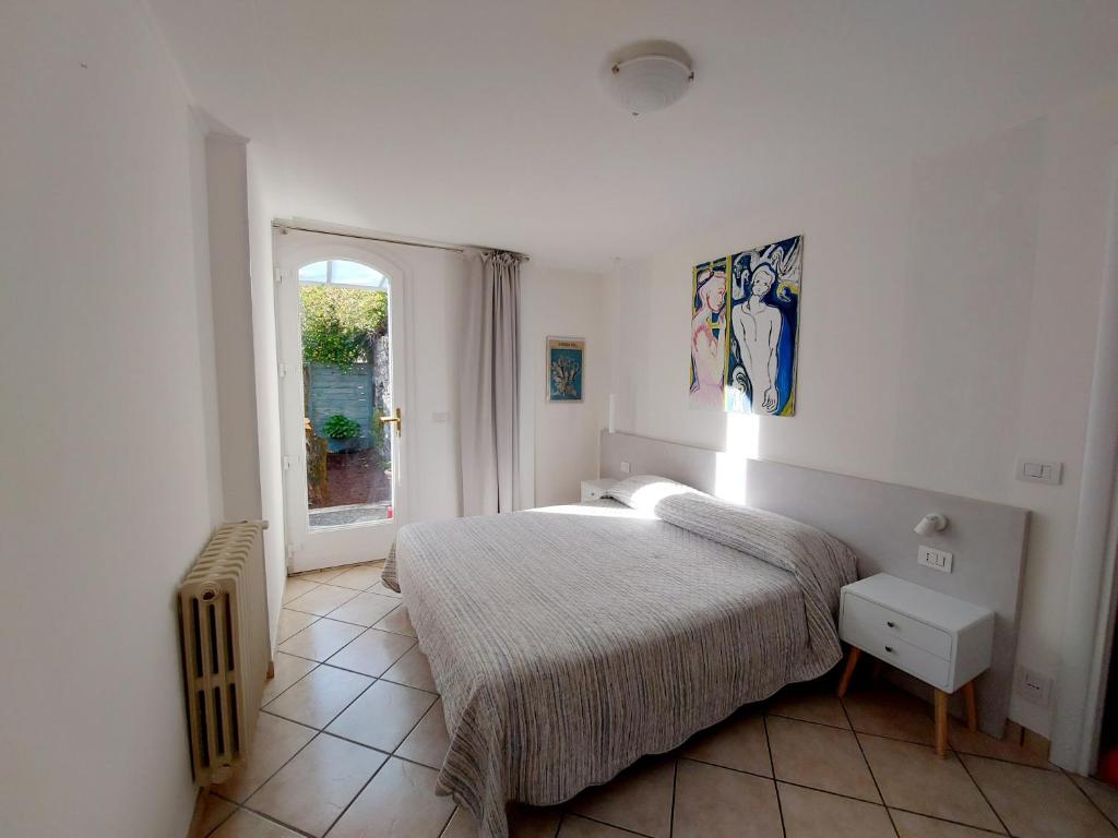 a white bedroom with a bed and a window at Dependance Belvedere in Recco
