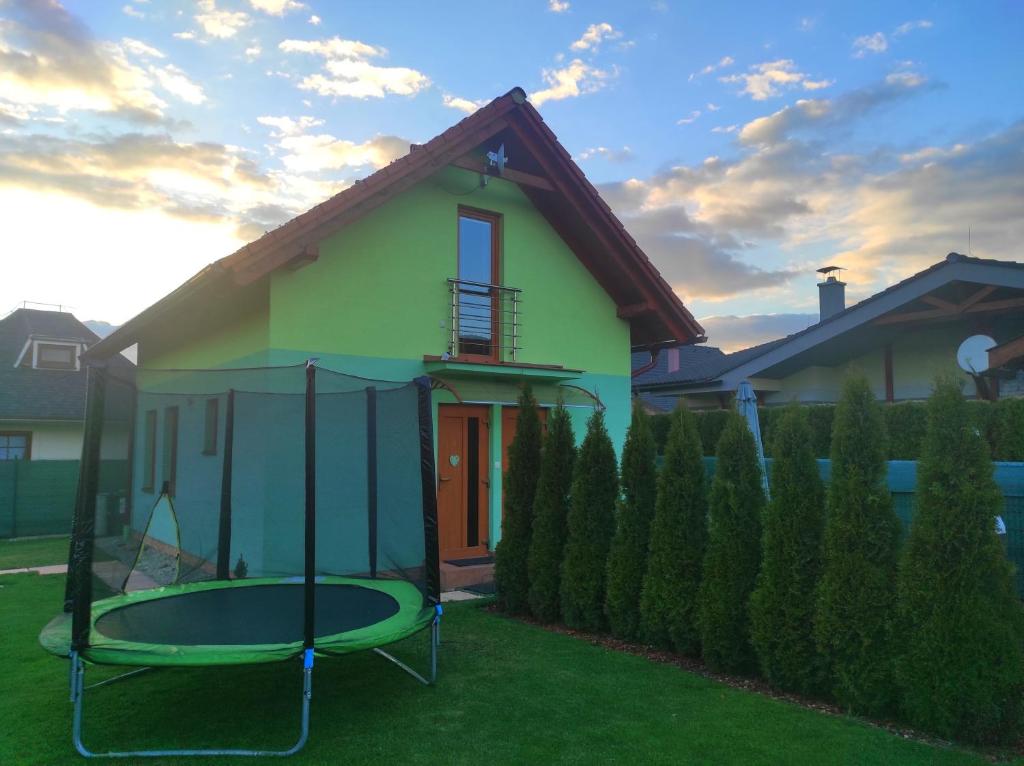 a house with a trampoline in the yard at Green cottage Besenova in Bešeňová