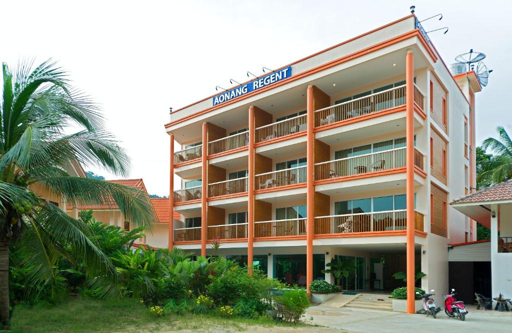 un hotel naranja con una palmera delante de él en Aonang Regent Hotel, en Ao Nang Beach