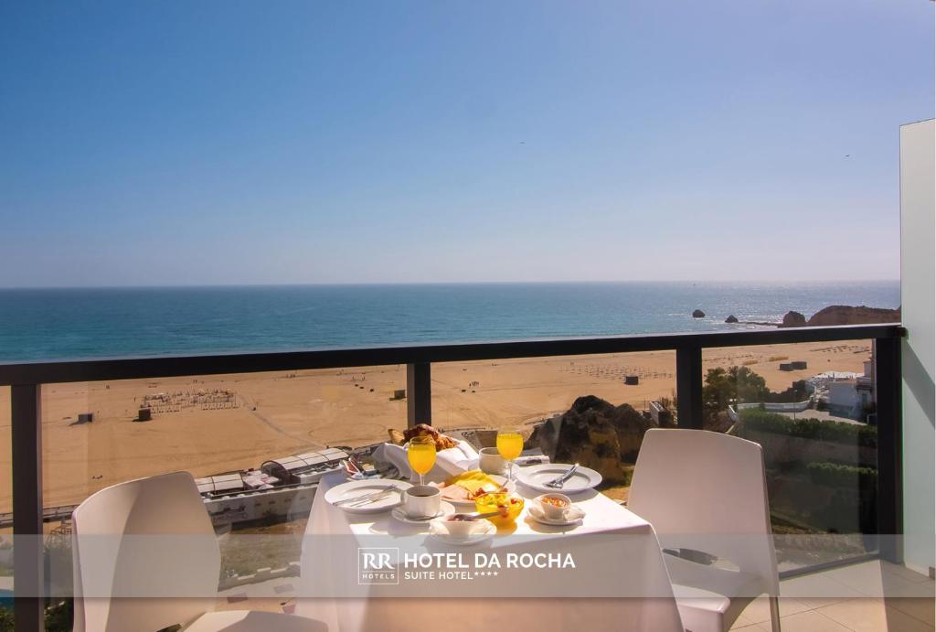 a table and chairs with a view of the beach at RR Hotel da Rocha in Portimão