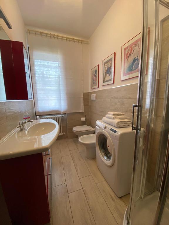 a bathroom with a washing machine and a sink at Love Italy Homes - Casa Lucia - Residence al Lago in Paratico