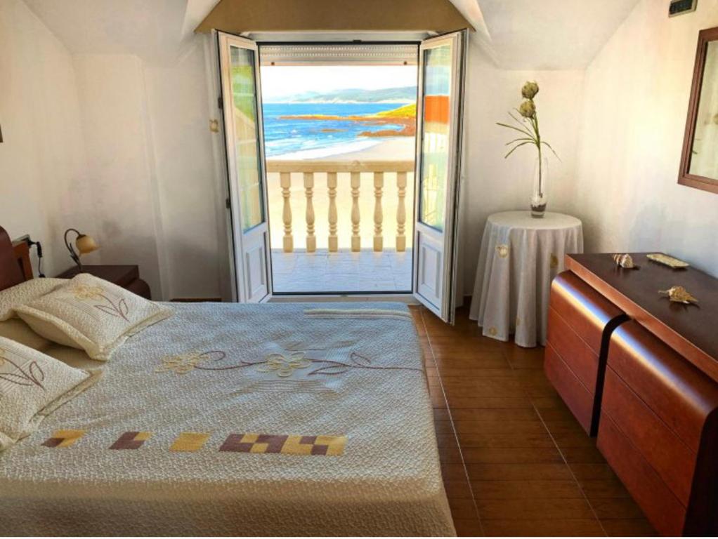 a bedroom with a bed and a door to a balcony at Casa da Moa in O Pindo