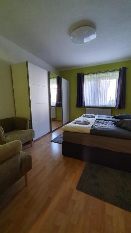 a bedroom with a bed and a couch and a window at Ferienwohnung Bautzen Süd in Bautzen
