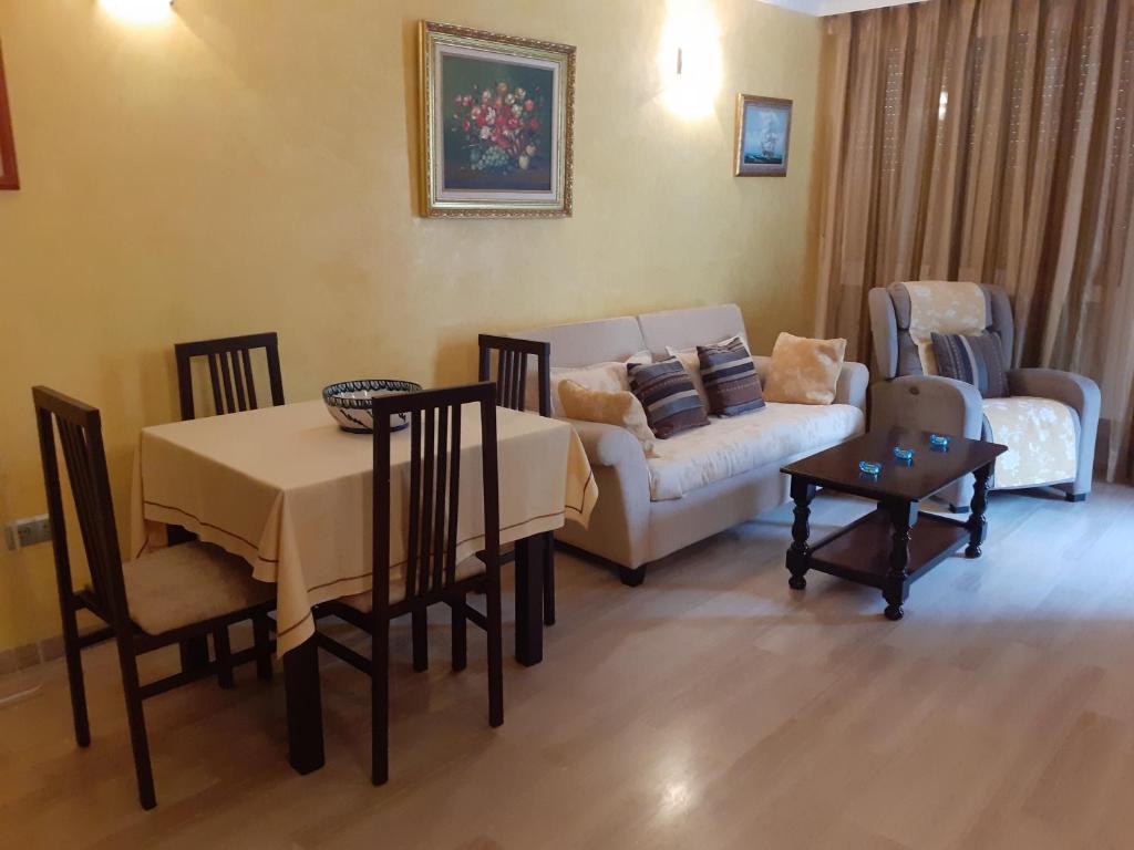 een woonkamer met een tafel en een bank bij Albaida II Bajo G Apartamento Nerja in Nerja