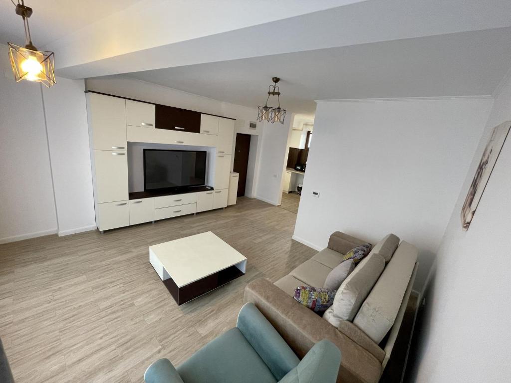 a living room with a couch and a tv at REYNA APART HOTEL in Constanţa