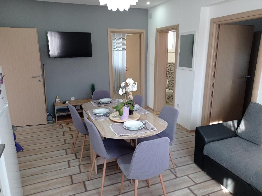 a dining room with a table and chairs and a couch at Apartment Antonia in Šibenik