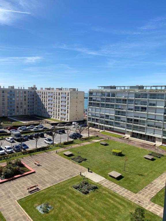 un parc en face d'un grand bâtiment dans l'établissement Vivez La forêt - Port de plaisance - Plage, au Havre