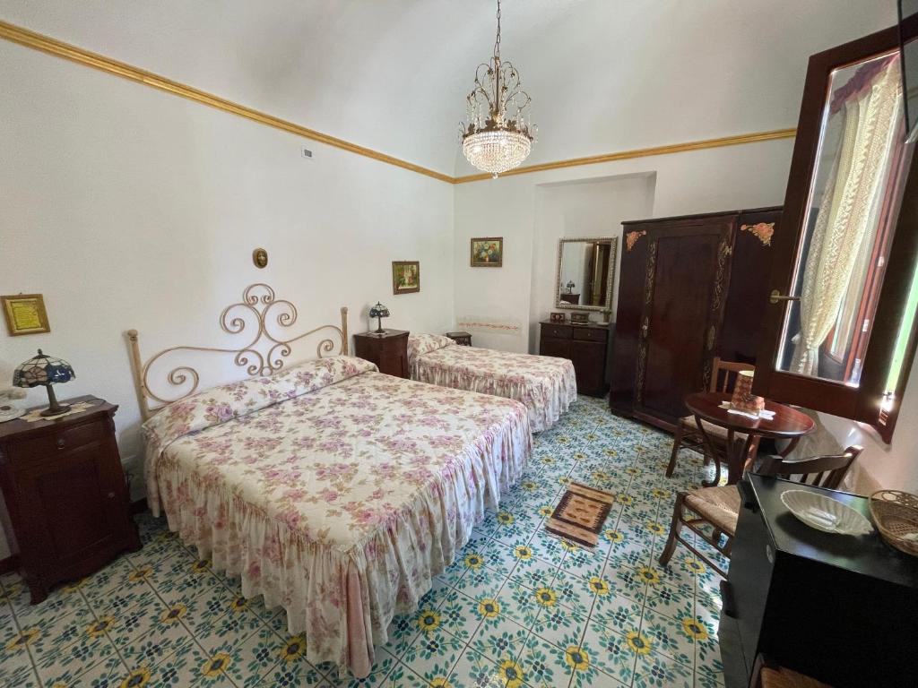 a bedroom with two beds and a chandelier at Guest House Al Gattopardo in Favignana