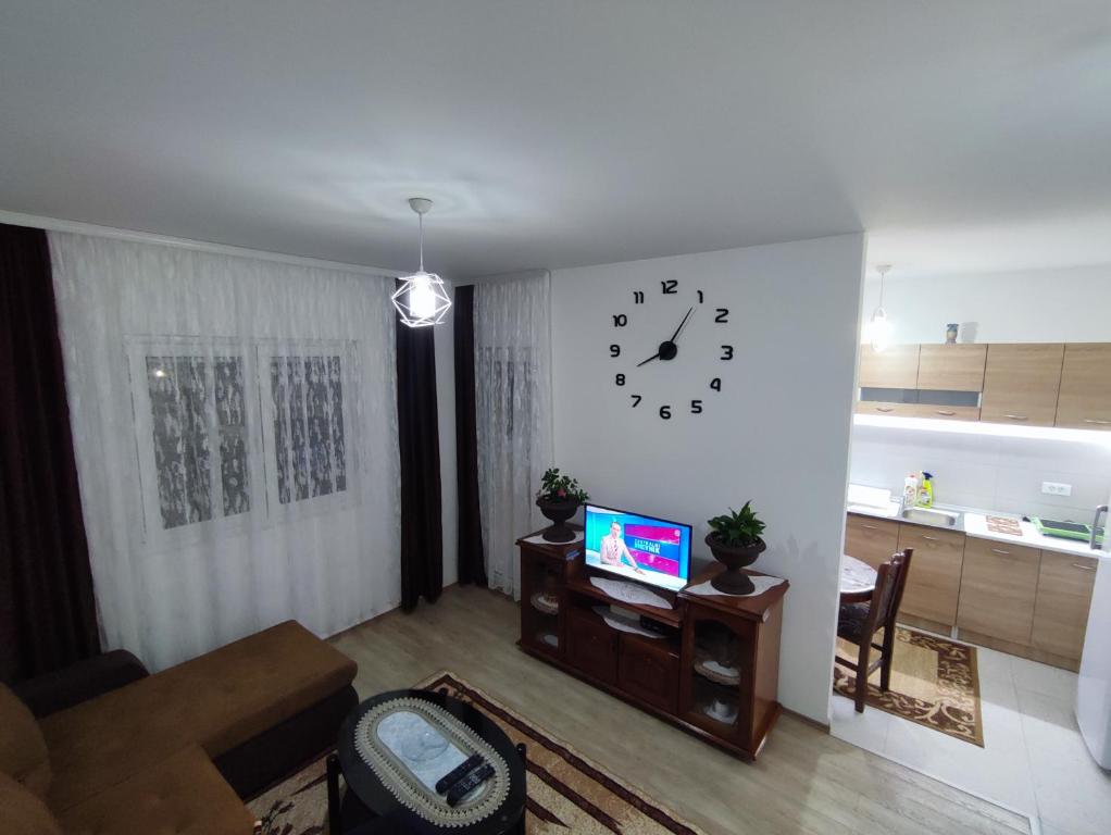 a living room with a clock on the wall at Apartment Sailor in Žabljak