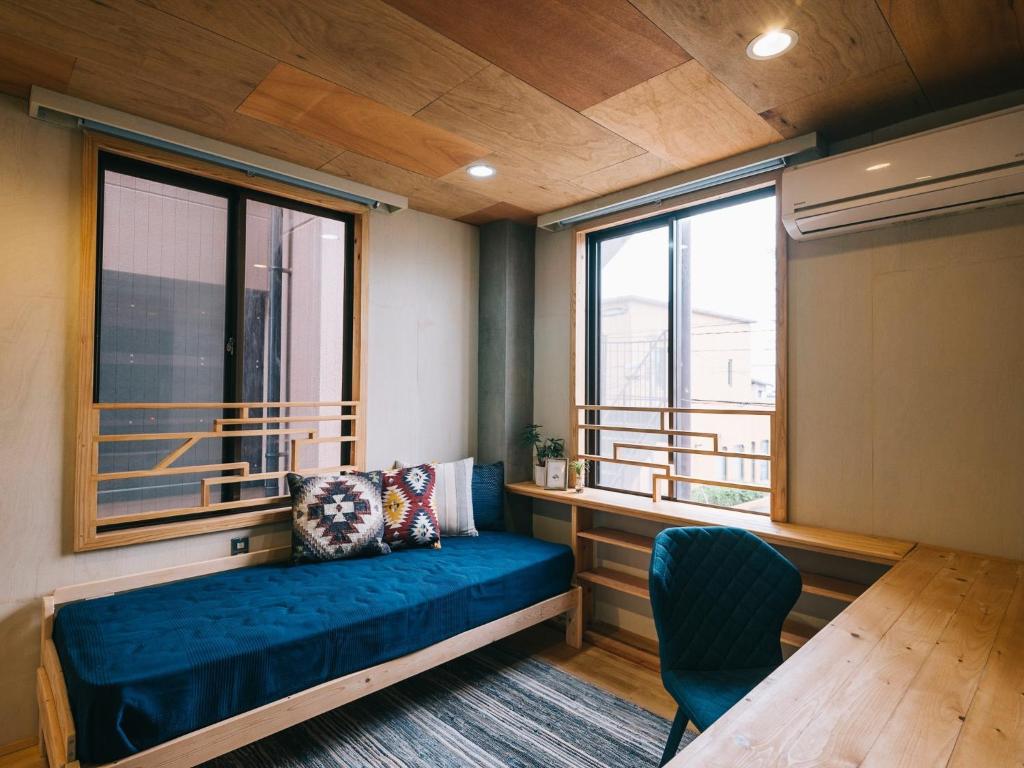 荒尾市にあるNoasobi Lodge 205- Vacation STAY 44527vの青いソファと窓が備わる客室です。