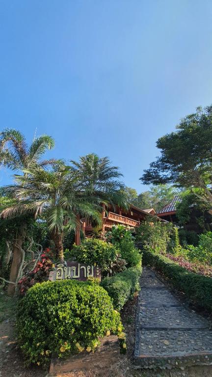 un jardin avec des palmiers et un chemin en pierre dans l'établissement Inpai Resort อินปายรีสอร์ท, 