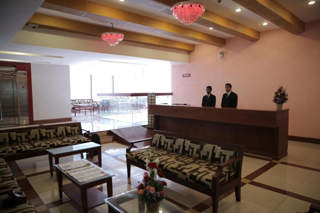 two men standing in the lobby of a building at Rain Drops Hotel in Chennai