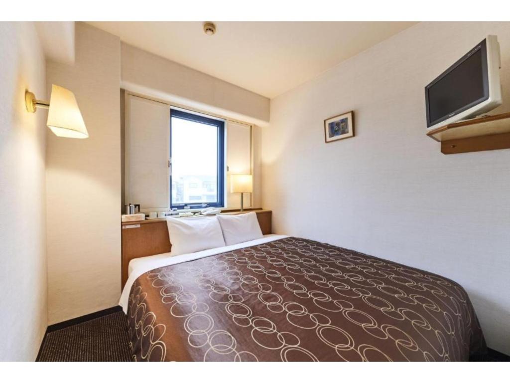 una camera con un grande letto e una TV a schermo piatto di Urayasu Sun Hotel - Vacation STAY 33007v a Urayasu