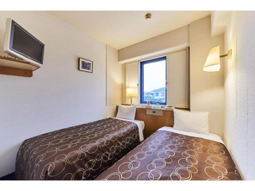 Llit o llits en una habitació de Urayasu Sun Hotel - Vacation STAY 33015v
