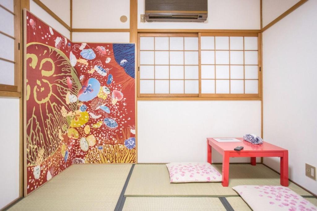 a room with a red table and a painting at someya - Vacation STAY 33875v in Kyoto