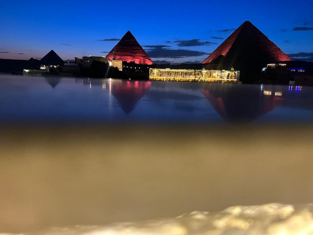 una vista de las pirámides desde el agua por la noche en Pyramids top success result en El Cairo