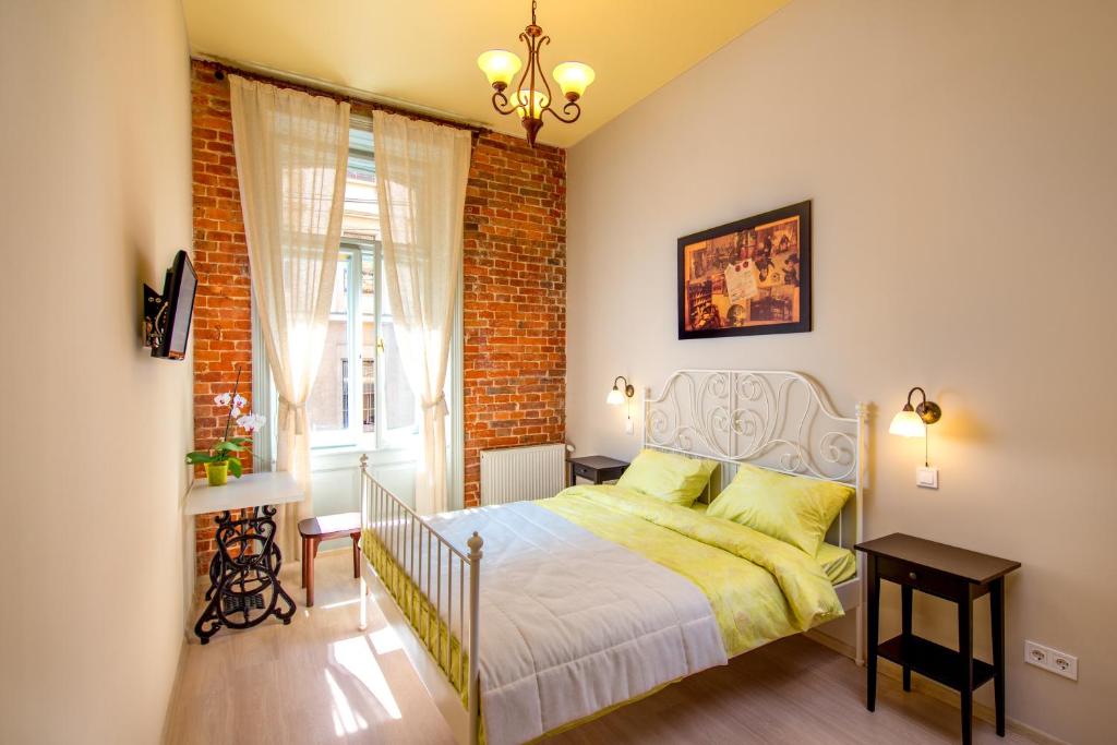 een slaapkamer met een bed en een bakstenen muur bij Post House Rooms in Lviv