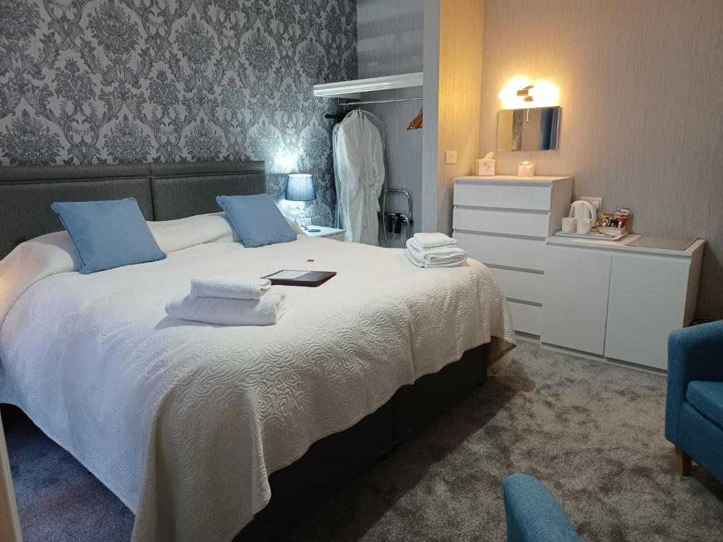 a bedroom with a large white bed with blue pillows at Palm Court in Weymouth